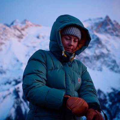 Frau in Kunstfaserjacke steht in verschneitem Gelände