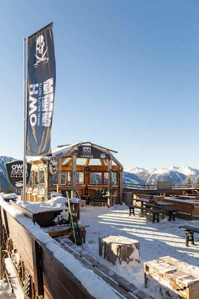 Auf der Sonnenterrasse weht die Fahne von Onkel Willy's Hütte mit dem unverkennbaren Logo.