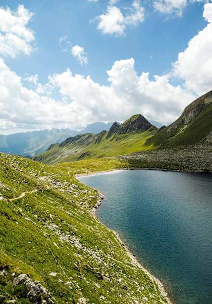 Ausblick auf den Eisbruggsee, dahinter ein mächtiges Bergpanorama