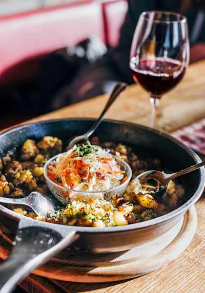 Gröstl und ein Glas Rotwein serviert auf der Graukogelhütte