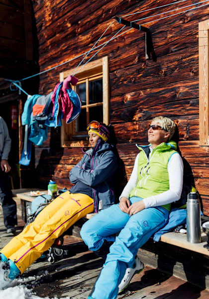 Kathrin und Eva genießen die Sonne auf der Hausbank der urigen Hütte
