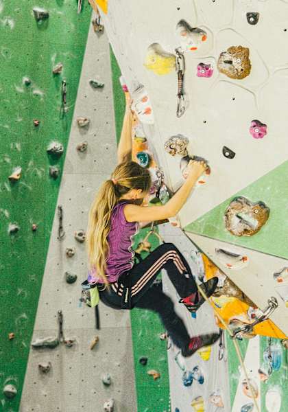 Ein Kind klettert in der Kletterhalle.