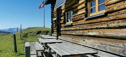 Gemütliche Sitzgelegenheit an der Holzwand des Naturfreundehauses Medergerfluh. 