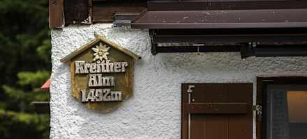 Die Kreither Alm mit ihrem Schild an der Hauswand