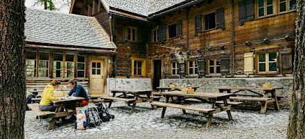 Die Chamanna Cluozza auf 1.882 Meter Seehöhe (oben) ist die einzige bewirtschaftete Hütte im Schweizerischen Nationalpark. Dort werden Nachhaltigkeit und Regionalität vor allem seit dem Umbau vor drei Jahren sehr ernst genommen: Das gilt für natürliche Baumaterialien wie Kalk und Stampflehm, die 30.000 Lärchenschindeln – und die Zutaten für die Speisen, etwa Alpentapas und Zwetschkenkuchen (unten).