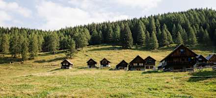 In einem Talkessel auf rund 1.500 Metern Seehöhe reiht sich hier Holzhaus an Holzhaus und ergibt so das Flair eines uralten Almdorfes.