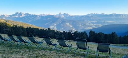 Parade der Liegestühle vor dem Panorama der Dolomiten.