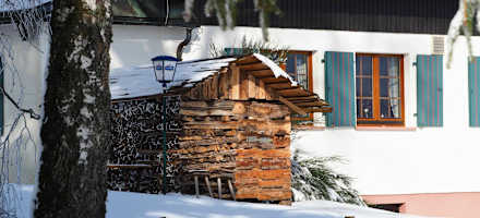 Die Wintersonne wärmt den Holzstapel beim Wanderheim Kreuzmoos
