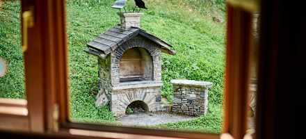 Vor der Hütte gibt es eine große Terrasse, einen Lagerfeuerplatz und einen gemauerten Griller.