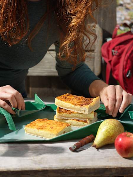 Frau beim Anrichten einer Käsewähe