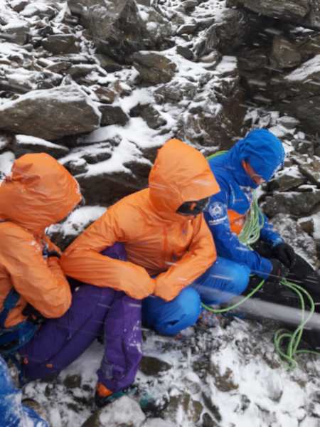 Die Teilnhemer harren am Fuß der Eigerjöcher aus, während ihnen der Wind um die Ohren pfeift