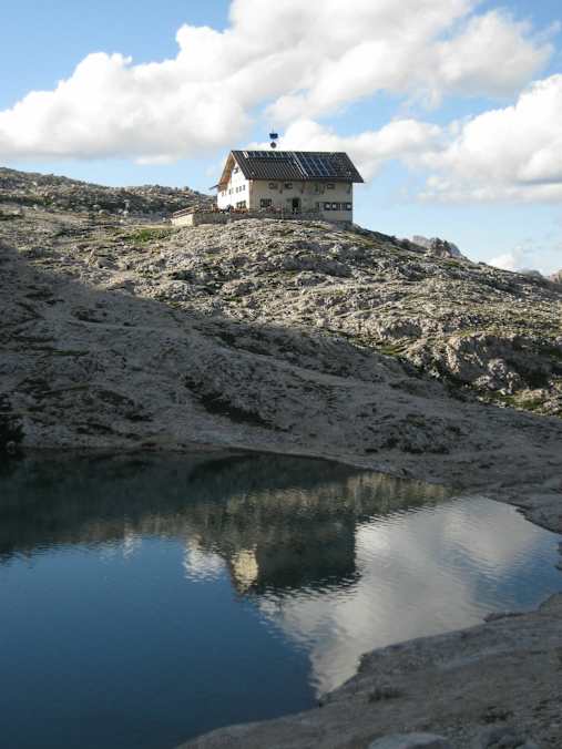 Die Pisciadù-Hütte steht in der nördlichen Sellagruppe und südlich des Grödner Jochs am Ufer des türkisfarbenen Pisciadùsees in Südtirol.