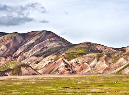 Landmannalaugar: Einsamer Wanderer in der Vulkanlandschaft von Landmannalaugar im Hochland. Buntes Rhyolith-Gestein teils mit Moos überwachsen.