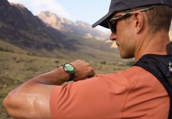 Outdoor-Sportler blickt auf seine HUAWEI WATCH GT 6 – präzises GPS-Tracking beim Laufen in den Bergen.