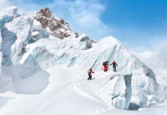 Die Gruppe vor einem imposanten Gletscherabbruch bei strahlend blauen Himmel.