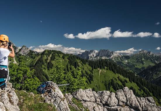 Eine Klettersteiggeherin macht am Ende der Via Ferrata Charmey im Kanton Freiburg ein Foto mit ihrem Handy.