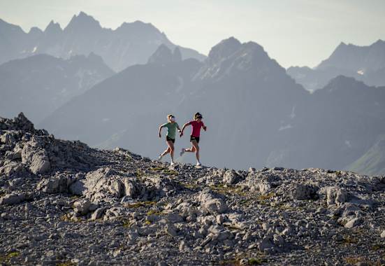 Zwei Frauen laufen über einen Berg