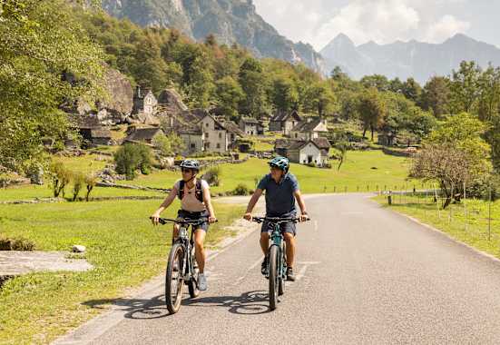 Zwei Fahrradfahrer fahren auf den gut ausgebauten Straßen im Kanton Tessin.