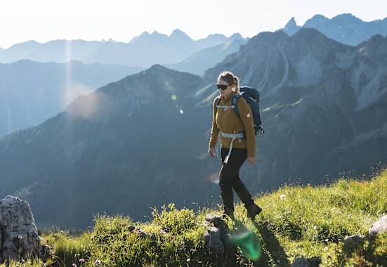 Eine Wanderin vor einer Bergkulisse.
