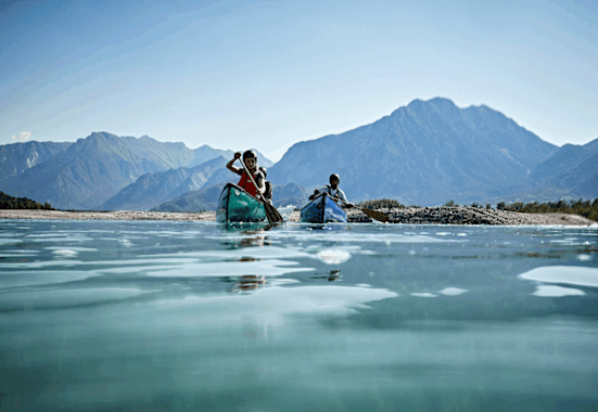 Per Kanu erkundet sich der Tagliamento am besten. Im Hintergrund erheben sich die Julischen Voralpen.