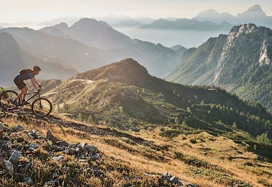 Abwärts in sanftem Licht: Mountainbiken mit Panoramablick.