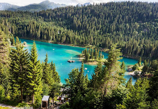 Ein See umgebene von Wäldern.