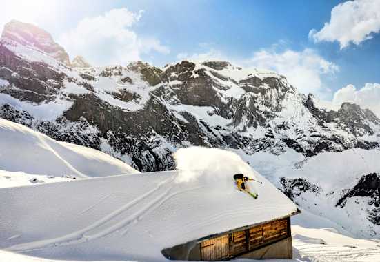 Ein Freerider fährt über das Dach einer Hütte.