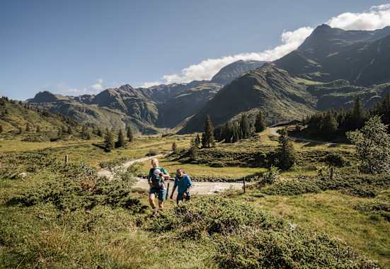 Zwei Wanderer mit Baby stapfen durch das Gasteinertal.