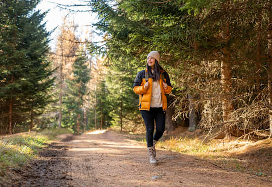 Frau wandert im wald im herbst