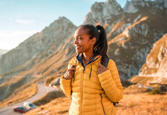 frau in den bergen beim wandern genießt den ausblick im herbst