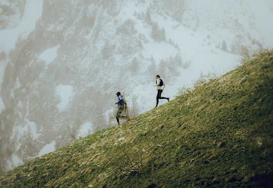 Zwei Trailerunner laufen mit der neuen Salomon Kollektion den Berg hinab.