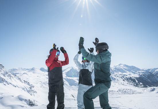 Drei SKifahrer klatschen sich in die Hände