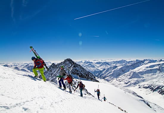 Die Alpinisten stapfen den Berg hinauf.
