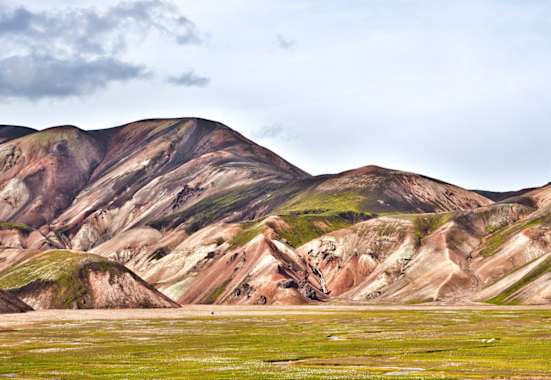 Landmannalaugar: Einsamer Wanderer in der Vulkanlandschaft von Landmannalaugar im Hochland. Buntes Rhyolith-Gestein teils mit Moos überwachsen.