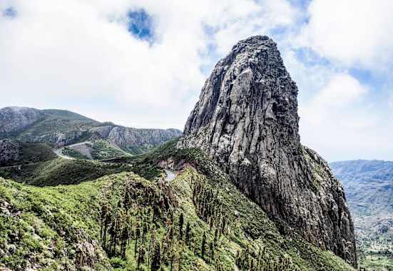 Ein Felsturm eingebettet in satten Grün