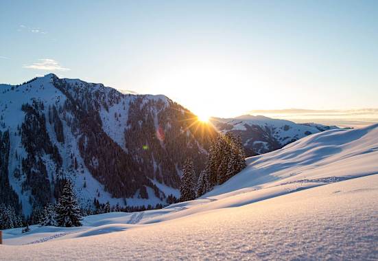 Die Abendsonne verschwindet hinter den schneebedeckten Gipfeln.