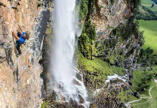 Kletterer klettert gesichert eine Bergwand hoch