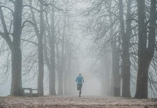 Läufer bei Nebel im Park