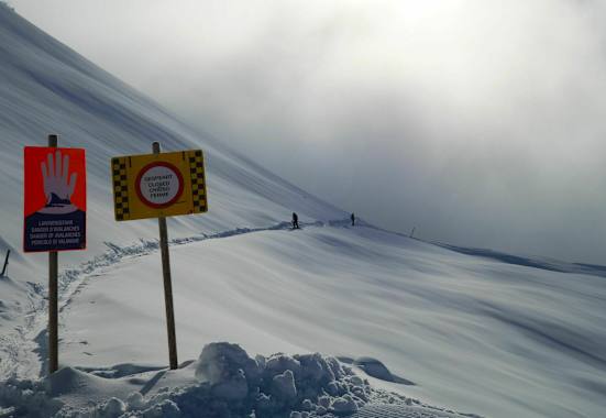 Schilder warnen vor Lawinengefahr im freien Gelände