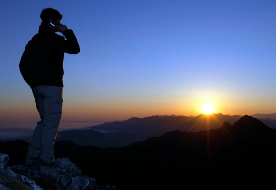 Notfall am Berg: Person im Gebirge am Handy