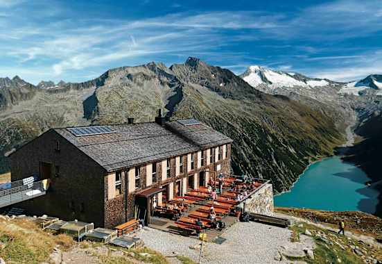 Die Olpererhütte besitzt einen Logenplatz über dem Schlegeis-Stausee. Dahinter Greinerkamm und der vergletscherte Möseler.