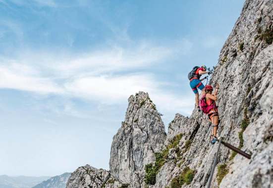 Kletterer am Pidinger Klettersteig und im Hintergrund das Alpenvorland