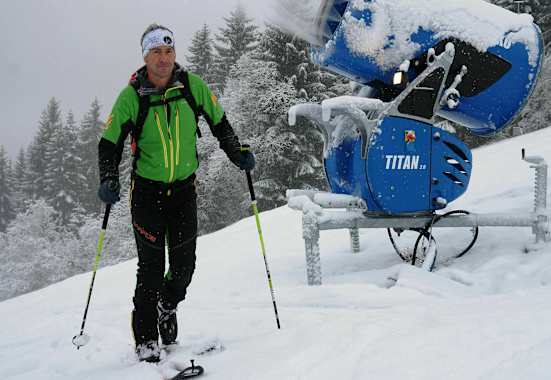 Skitourengeher im Skigebiet auf präparierter Piste