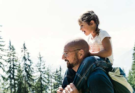 Das kleine Mädchen Lina sitzt auf den Schultern ihres Papas.