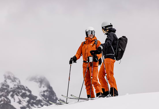 Zwei Personen auf dem Berg mit Ski und Ausrüstung von Skinfit.