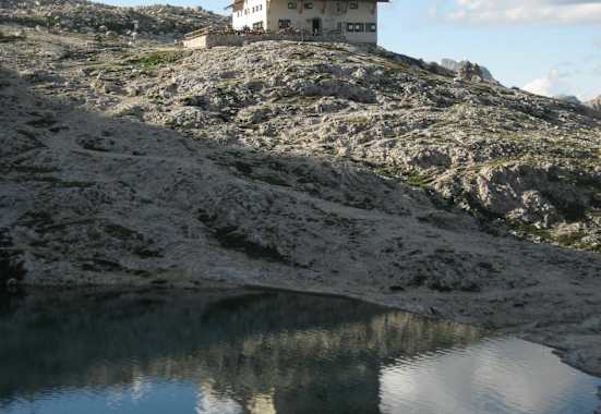 Die Pisciadù-Hütte steht in der nördlichen Sellagruppe und südlich des Grödner Jochs am Ufer des türkisfarbenen Pisciadùsees in Südtirol.