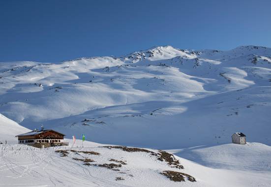 Die Sesvennahütte ist ein perfektes Basislager für Skitourengeher. Hinten die Rasass-Spitze (2.941 m) zum Eingehen.