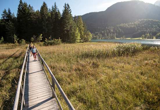 Wanderer am Lautersee mit Alm im Hintergrund