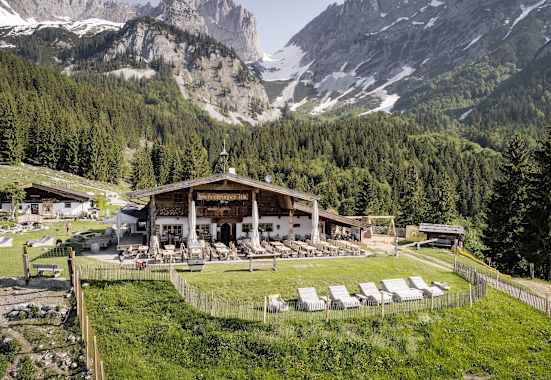 Holzliegen laden auf der großen Sonnenterrasse der Wochenbrunner Alm zum Relaxen ein.