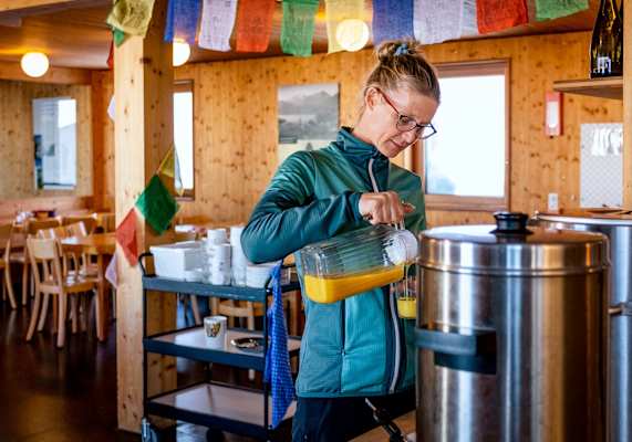 Eine Frau schenkt Orangensaft in ein Glas.
